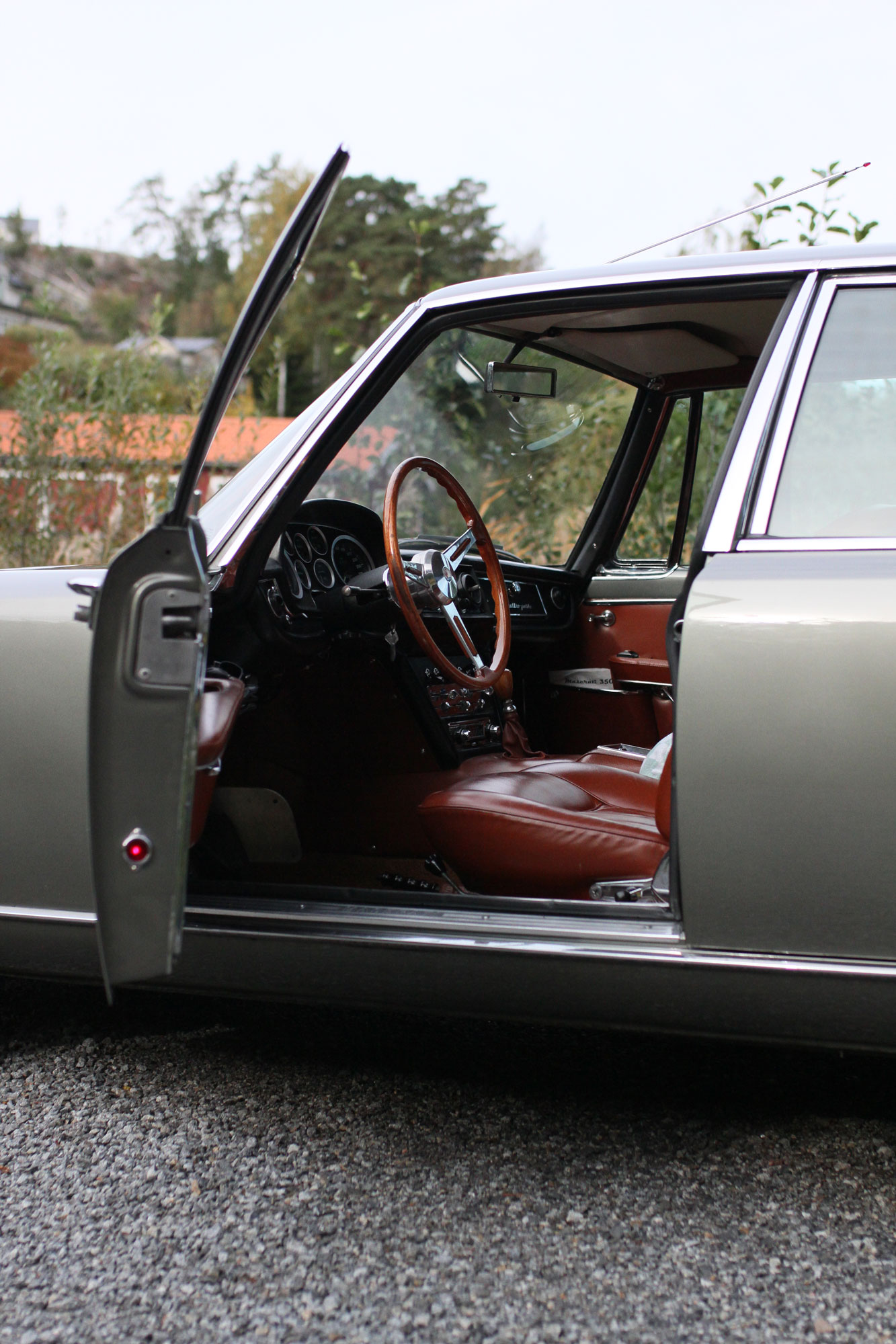 Maserati Quattroportes driver's door is open. Inviting picture to the driver's environment with wooden steering wheel