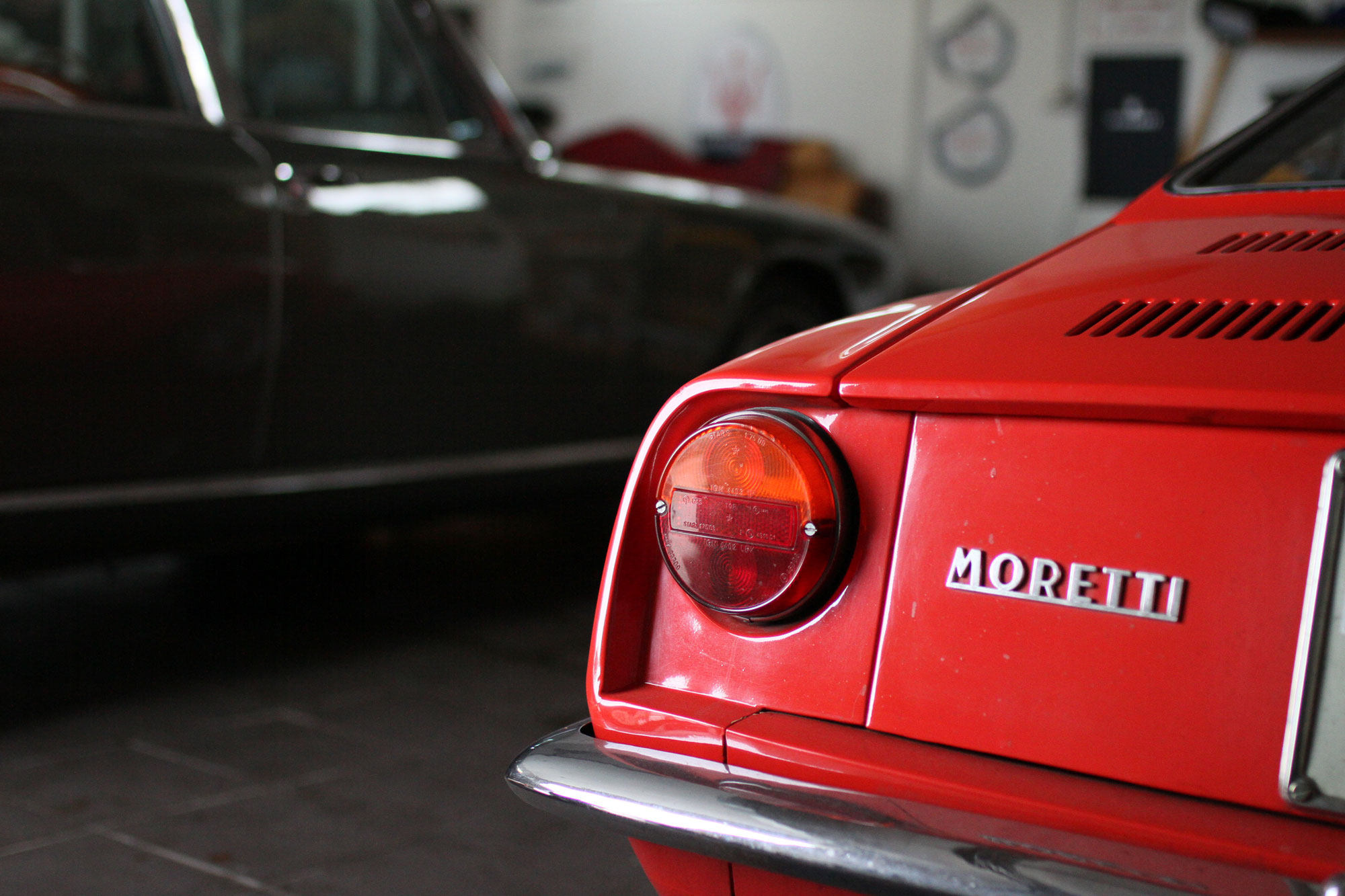 Moretti 850 from behind with Quattroporte behind, next to the garage