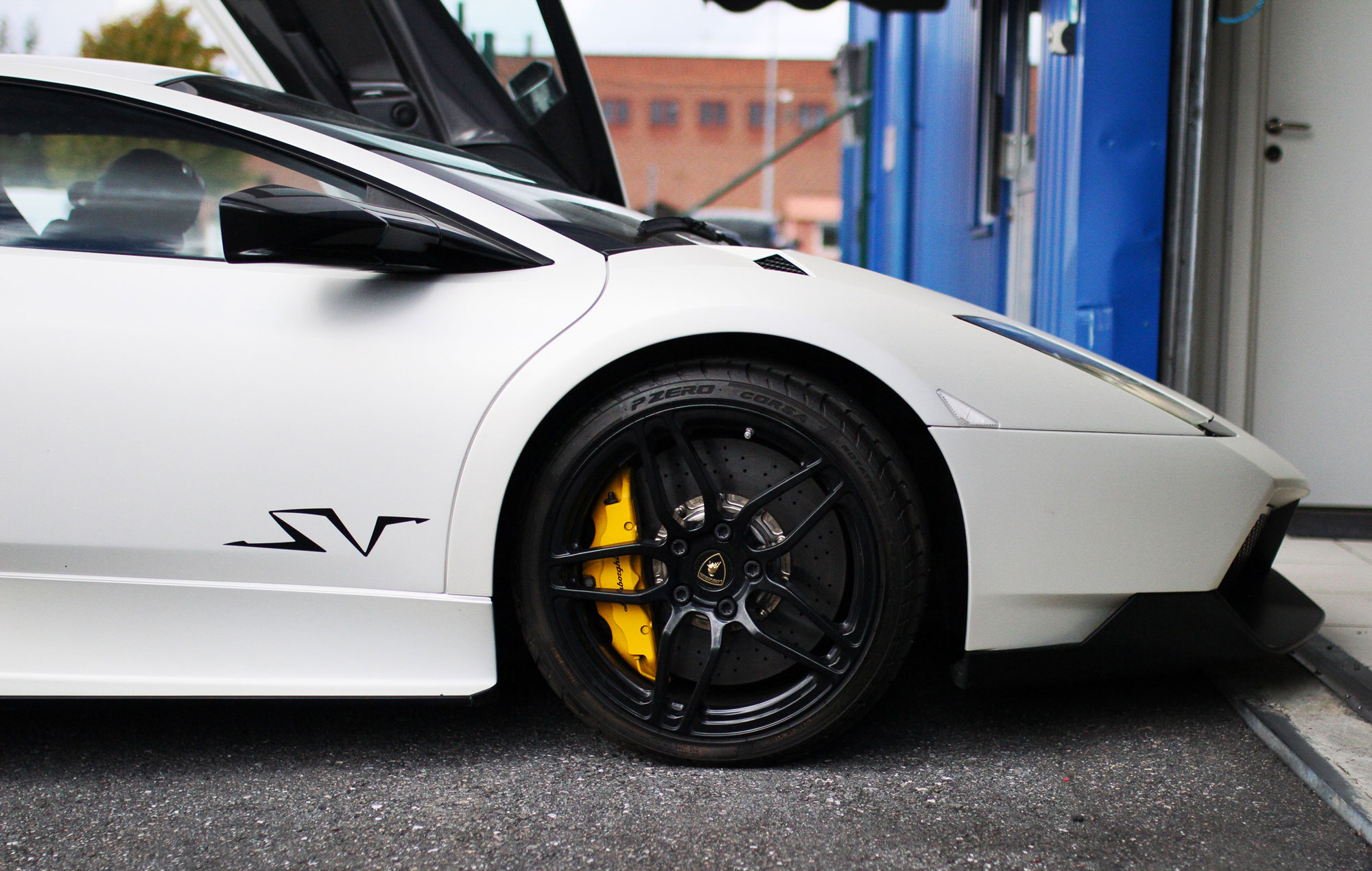 LAmborghini Murcielago SV Grey Number 1 outside the blue garage house